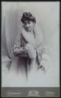 cca 1910 Hölgy bundában és gyöngy nyaklánccal, keményhátú fotó Krazanowski csernovici műterméből, 21×13 cm