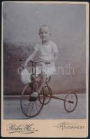cca 1910 Gyerek háromkerekű biciklivel, keményhátú fotó Békei budapesti műterméből, kis kopásnyomokkal, 16×10 cm / child with bicycle, vintage photo