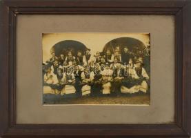 cca 1920-30 Zenészek és táncosok magyaros népviseletben, feltehetően hagyományörző egyesület tagja. Vintage fotó kartonon, Árvay József fényképész bélyegzőjével a kartonon. Üvegezett fa keretben, 15,5×21,5 cm