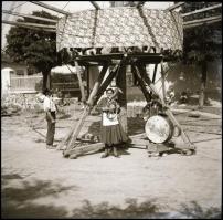 cca 1936 Thöresz Dezső (1902-1963) békéscsabai gyógyszerész és fotóművész hagyatékából  4 db vintage NEGATÍV, falusi búcsúban felállított körhinta, amelyet emberi erővel forgattak; a felső rész ugyan el van takarva, de a srácok lába a forgatóplatón jól látszik, akik nyilván egy-két ingyen menetért szívesen hajtották naphosszat a körhintát; a sörgő tövében trombitás asszony toborozza a fizető vendégeket, 6x6 cm