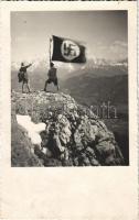 NSDAP German Nazi Party propaganda, hikers with swastika flag on a mountain peak. photo