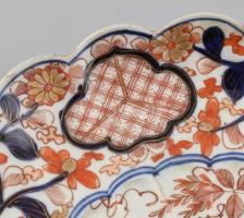 Imari tál porcelán, öblében máz alatti kékkel, máz felett vörössel és arannyal festett virág ábrázol...