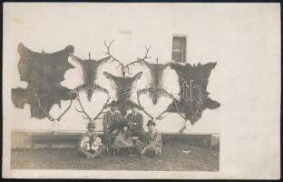 cca 1910 Vadászok házfalán kilógatott állatbőrökkel és trófeákkal, fotó, hátoldalt névvel, 8,5×13,5 cm