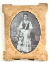 cca 1920-1940 Fiatal hölgy magyar népviseletben, fotó, régi, dekoratív üvegezett réz képkeretben, a kereten kisebb kopásnyomokkal, külső méret: 18x14,5 cm, látható méret: 13,5x9,5 cm