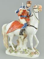 Meissen. Huszár. Egy előretörő fehér lovat egy szőrmekarimás sapkában és kék köpenyben lovagló huszár vezet. Festett porcelán, alján kék kardos jelzettel, 1132 és masszába nyomott 119-es számmal, sérült, restaurált, m: 27 cm