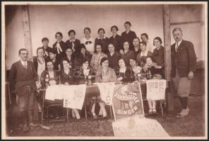 cca 1920-1930 Dévaványai műhímző- és varró tanfolyam csoportképe, Singer varrógép reklámplakáttal, k...