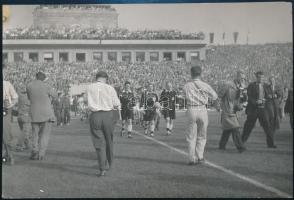 1955 Bp., Népstadion, magyar-szovjet (1-1) labdarúgó mérkőzés, játékosok, játékvezetők és fotósok a pályán, a Képes Sport pecsétjével jelzett, feliratozott fotó, 18x12 cm