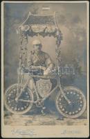 cca 1910-1920 Kerékpáros feldíszített biciklivel, keményhátú fotó Hegedűs Vilmosné szentesi műterméből, szecessziós hátlappal, 16,5×10,5 cm