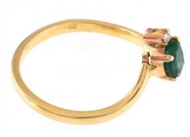 Arany (Au/18k) Női gyűrű, 1db természetes smaragddal ékítve cca. 0,30ct, 1db modern csiszolású brill...