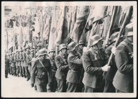 cca 1930-1940 Magyar katonák felvonulása történelmi zászlókkal, fotó, hátoldalán pecséttel jelzett (H.M. Film-Foto), sarkán kis törésnyomokkal, 18x12,5 cm
