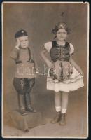 cca 1930 Kisgyerekek magyaros ruhában, fotólap Weiner Antal battonyai műterméből, kis hibákkal, 13,5×8,5 cm