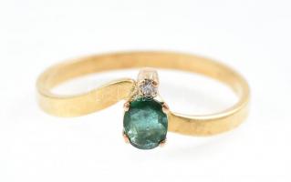 Arany (Au/18k) Női gyűrű, 1db természetes smaragddal ékítve cca. 0,30ct, 1db modern csiszolású brill...