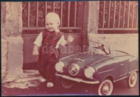 cca 1960 Kisgyerek lemez játékautóval, színes fotó, 9x14 cm