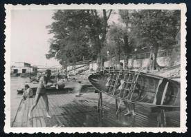 1942 A népszigeti Óbudai Gázgyári Csónakháznál csónak tisztítása, hátoldalon feliratozott fotó, 6,5×8,5 cm
