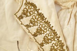 Régi kislány alkalmi ruha, szoknya és felső, brokát vagy szatén, aranyszínű zsinórral, csipkével. A ...