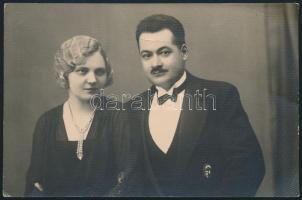 cca 1938 Vitézi jelvényt viselő katonatiszt feleségével, elegáns polgári öltözetben, fotólap, hátoldalán pecséttel jelzett (Magyar Fotó Műterem), 13,5x8,5 cm
