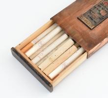 Iparművész vörösréz cigarettatartó doboz, benne többféle cigaretta, 22×8,5×2 cm