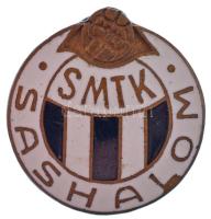 ~1950. SMTK Sashalom zománcozott bronz gomblyukjelvény (19mm). A Sashalmi MTK csapatát 1920-ban alapították Cinkotai Ehmanntelepi SE néven, ekkor a II. osztályba nyertek besorolást, ám innen 1922-ben kiestek, s egyből az V. osztályban találták magukat. Itt bronzérmet szerezve egyből a III. osztályba kerültek, ahol 1924-ben bronzot, 1925-ben ezüstöt ünnepelhettek. Ekkor jutottak vissza a II. osztályba, s innentől Sashalmi ASC néven szerepeltek. Tíz szezont töltöttek a II. osztályban, legjobb eredményük két bronzérem volt a Barcza-csoportban. 1932 után, a Középmagyarországi LASZ alá tartozó három csoport összevonása után már gyengén szerepeltek, 1936-ban pedig ki is estek, s csak a IV. osztályban álltak rajthoz Hargita néven. 1944-ig (egy szezon kivételével) végig ebben az ligában szerepeltek, majd az 1944-45-ös félbeszakadt idényt a harmadik vonalban kezdhették meg. 1945-46-ban a II. osztálynak megfelelő BLSZ I-ben találták magukat Sashalmi MADISZ néven, egy szezont követően pedig felvették a Sashalmi MTK elnevezést. Bár 1946 és 1948 között is a BLSZ I-ben szerepeltek, az átszervezések miatt ez már csak a III. osztályt jelentette, majd egy újabb átszervezés után az 5. helyen végző sashalmiak az NB III Bíró Dezső-csoportjába kaptak besorolást. Itt utolsók lettek, visszakerültek a BLSZ I-be, ami már csak a IV. osztálynak felelt meg. Az 1950 őszi bajnokságban innen is kiestek, ám ismét átszervezések történtek, így bár a BLSZ II-ben folytatták, továbbra is IV. osztályúak voltak. Ebben a szezonban a klub nevében az MTK-t felváltotta a Petőfi, ami maradt is egészen 1955-ig. 1952-ben a Sashalmit is lecserélték, mégpedig XVI. Kerületire. Ebben az évben ezüstérmet szerezve visszajutottak a BLSZ I-be, immár XVI. Kerületi Petőfi néven. 1955-től két idényen át XVI. Kerületi Bástya néven futottak, ebben az évben ki is estek a BLSZ I-ből, 1956-ban viszont a BLSZ II-ben a klub történetének első bajnoki címét megszerezve visszajutottak. Az 1957-58-as szezont már a BLSZ I-ben kezdték meg, ami az újabb átszervezések miatt továbbra is IV. osztályt jelentett. 1958 tavaszán bejelentették, hogy a XVI. Kerületi Petőfi egyesül a Vasas Elektronikus SK-val, az új klub pedig Sashalmi Elektronikus néven indul majd. A XVI. Kerületi Petőfi, a volt Sashalmi MTK utolsó szezonjában a 15. helyen végzett BLSZ I. Közép csoportjában. T:2 zománchiba