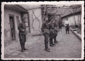 1941 Szabadka (Subotica), Vajdaság, magyar katonák egy ház udvarán, egyikük szuronyos puskával, II. világháborús fotó, a hátoldalon feliratozva, 8,5x6 cm