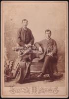 cca 1883-1886 Két fiatal férfi paddal, festett háttér előtt, keményhátú kabinetfotó, Békei H[ermin] - ezelőtt Mai és Társa - budapesti fényképészeti műteremből, 16x11,5 cm