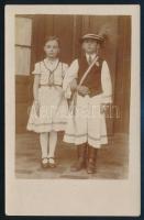 cca 1920 Március 15-i ünnepségre öltözött gyerekek kokárdával és nemzeti színű szalagokkal, népviseletben, eredeti fotó, szép állapotban, 14×9 cm
