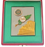 1971. Miskolci Vasutas Sport Club (MVSC) fém plakett zománcozott és aranyozott rátétekkel a klub alapításának 60. évfordulója alkalmából (59x80mm) + MVSC zománcozott fém jelvény, mindkettő eredeti dísztokban. A zöld-fehér színeket viselő Miskolci Vasutas SC-t 1911-ben alapították. A csapat a kezdetektől egészen 1937-ig folyamatosan II. osztályú volt. A kiesésig három bajnoki címet, három ezüstérmet és hat bronzérmet szerzett. Az 1937-es kiesést követően két szezon után visszajutott az addigra NB II-nek nevezett másodosztályba, s tagságát meg is tartotta egészen 1946-ig, majd egy III. osztályú idény után visszajutottak. 1948-ban a klubot Miskolci Lokomotívnak, majd 1955-ben egy idény erejéig Miskolci Törekvésnek hívták. 1956-tól ismét MVSC, ez idő alatt végig az NB II-ben játszott a csapat. 1958-ban aztán az MVSC történelme során először összejött az, ami a városi rivális Diósgyőrnek már régóta: az NB II-t megnyerve feljutottak az NB I-be. Innen egyből kiestek, s nem is tértek már vissza soha. Lassú süllyedés következett a klub életében, 1969-ig II. osztályúak voltak, majd következett öt idény a III. osztályban a visszajutásig. Ekkor már csak négy szezont töltöttek a másodvonalban, mikor is zsinórban két kiesést követően 1983-ban a megye I-ben (IV. osztály) találták magukat. Innen még azonnal sikerült visszajutni, azonban ismét kiestek, s következett hatszezonnyi megye I-es szereplés. 1991-ben sikerült a visszajutás az NB III-ba, sőt, 1994-ben még az NB II is összejött, azonban újra megindultak lefelé: az ezredfordulóra újra a megye I-ben találták magukat, ami akkor már csak az V. osztályt jelentette. 2005-ben jártak utoljára az NB III-ban (IV. osztály), azóta szinte minden idényben a megye I-et erősítették, de két szezont eltöltöttek a megye II-ben is. T:1,1-