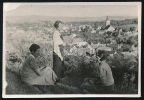 1936 Vízakna, Erdély, Szeben megye, a város látképe, előtérben fiatal hölgyekkel, hátoldalán feliratozott vintage fotó, bal szélén kissé sérült, 5,5x8 cm