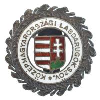 ~1930. Közép-magyarországi Labdarúgók Szövetsége zománcozott, ezüstözött fém gomblyukjelvény. Az 1922-1923-as szezontól kezdve a KMLSZ bonyolította le az I. osztálynak számító bajnokság, majd 1926-tól a profi I. osztály alatt működő, földrajzilag hozzá tartozó amatőr bajnokságokat. Ez idő tájt olyan klubok versenyeztek a KMLSZ égisze alatt működő bajnokságokban, mint a Kecskeméti TE, a Szolnoki MÁV, a SZAC, a Vác, a Budafok, a Dunaharaszti, a Csepel, a Vecsés, a Dorog, a Monor, a Dunakeszi, a Csillaghegyi MTE, vagy a Balassagyarmat. 1951-ben a KMLSZ-hez hasonló regionális szervezeteket felváltották a megyei szervezetek. T:AU apró zománchiba