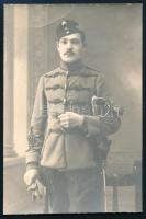 cca 1916 Huszár portréja, sapkajelvényekkel, karddal, fotó, felületén törésnyom, 9×6 cm