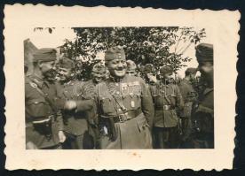 cca 1943 Katonatiszt katonák között, vitézi jelvénnyel, fotó, 5×7,5 cm