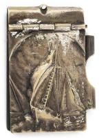 Ezüstözött alpakka notesztartó, fedelén vitorláshajó díszítéssel, hátoldalán vésett Abbazia (Abbázia / Opatija) felirattal, benne noteszlapokkal. XX. sz. eleje. Jelzett, korának megfelelő kis kopásokkal, 5x3 cm