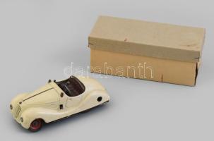 Schuco Examico 4001 felhúzós lemezjáték autó, 1936-1940 körül. Cabrio kivitelű, világos vajszínű oldtimer automobil, formatervezése leginkább a BMW 328-as típusára hasonlít. Fém, jelzett (Made in Germany), felhúzókulcs nélkül, korának megfelelő kisebb kopásokkal, hátulján kisebb horpadással, h: 14,5 cm / Vintage German clockwork tin toy car, without wind-up key, with slight wear