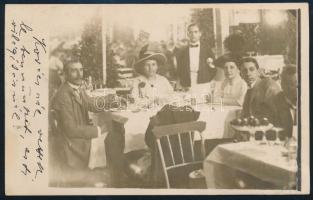cca 1910-1920 Elegáns asztaltársaság Kovács vendéglőjében, vintage fotólap, feliratozva, hátoldalán kisebb ragasztónyomokkal, 13,5x8,5 cm