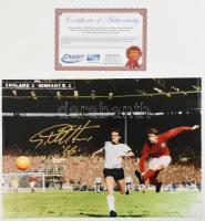 Geoff Hurst angol labdarúgó, az 1966-os világbajnok angol válogatott tagja (ahol elsőként rúgott győztes világbajnoki döntőben mesterhármast) autográf aláírása őt ábrázoló fotónyomaton, tanúsítvánnyal, 42x29,5 cm / Autograph signed photo of Geoff Hurst English footballer, 1966 World Cup winner (where he was the first to score a hat-trick as the winner of a World Cup final), with certificate, 42x29.5 cm