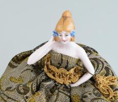 Régi kis teababa, porcelán, textil ruhával. m: 14 cm