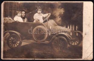 cca 1930 Autombilban ülő gyerekek anyjukkal, fotólap, jelzés nélkül, törésnyomokkal, kissé foltos, 9x14 cm