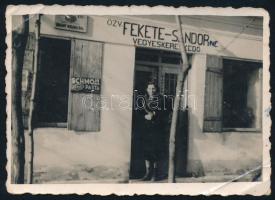 cca 1940 Fekete Sándorné vegyesboltjának bejárata, M. kir. Dohányáruda és Schmoll Pasta reklámfeliratok, fotó, 5,5×8 cm