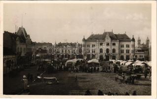 1938 Léva, Levice; Fő tér, Üdvözöljük magyar testvéreinket! bevonulás, piac, Singer, Ignác Trebitsch, Pál L., Vámos, Borcsányi és Csernák és Kürti üzlete, autóbusz / entry of the Hungarian troops, market, shops, autobus + "1938 Léva visszatért" So. Stpl. (EK)