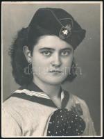 cca 1940 Gimnazista lány iskolai egyenruhában, sapkában, címeres sapkajelvénnyel; nagyméretű fotó, 23,5x17,5 cm