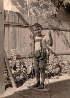cca 1930 Kisgyerek hintán állva, fotó, 23×17 cm