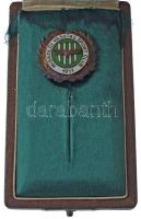 ~1960. "Miskolci Vasutas Sport Club (MVSC)" zománcozott fém jelvény eredeti dísztokban. A zöld-fehér színeket viselő Miskolci Vasutas SC-t 1911-ben alapították. A csapat a kezdetektől egészen 1937-ig folyamatosan II. osztályú volt. A kiesésig három bajnoki címet, három ezüstérmet és hat bronzérmet szerzett. Az 1937-es kiesést követően két szezon után visszajutott az addigra NB II-nek nevezett másodosztályba, s tagságát meg is tartotta egészen 1946-ig, majd egy III. osztályú idény után visszajutottak. 1948-ban a klubot Miskolci Lokomotívnak, majd 1955-ben egy idény erejéig Miskolci Törekvésnek hívták. 1956-tól ismét MVSC, ez idő alatt végig az NB II-ben játszott a csapat. 1958-ban aztán az MVSC történelme során először összejött az, ami a városi rivális Diósgyőrnek már régóta: az NB II-t megnyerve feljutottak az NB I-be. Innen egyből kiestek, s nem is tértek már vissza soha. Lassú süllyedés következett a klub életében, 1969-ig II. osztályúak voltak, majd következett öt idény a III. osztályban a visszajutásig. Ekkor már csak négy szezont töltöttek a másodvonalban, mikor is zsinórban két kiesést követően 1983-ban a megye I-ben (IV. osztály) találták magukat. Innen még azonnal sikerült visszajutni, azonban ismét kiestek, s következett hatszezonnyi megye I-es szereplés. 1991-ben sikerült a visszajutás az NB III-ba, sőt, 1994-ben még az NB II is összejött, azonban újra megindultak lefelé: az ezredfordulóra újra a megye I-ben találták magukat, ami akkor már csak az V. osztályt jelentette. 2005-ben jártak utoljára az NB III-ban (IV. osztály), azóta szinte minden idényben a megye I-et erősítették, de két szezont eltöltöttek a megye II-ben is. T:1,1-