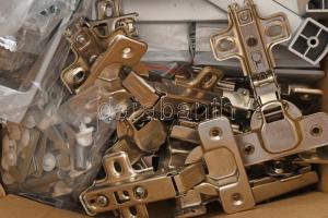 Egy doboznyi bútorszerelési alkatrész, közte értékesebb darabokkal