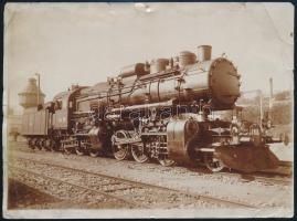 cca 1915 MÁV 601. sorozatú, Mallet-rendszerű hegyi gőzmozdony egy vasútállomáson, fotó, a hátoldalon feliratozva, szélein kisebb sérülésekkel, ázásnyommal, 17,5x13 cm / cca 1915 Hungarian State Railways steam locomotive at a station, photo, slightly damaged edges, water stain, 17.5x13 cm