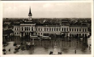 Óbecse, Stari Becej; községháza, Szent István tér eső után, MÁVAUT autóbuszok, Hubet Izidor, Janek Testvérek, Bata cipő és fodrászterem üzlete, piaci bódék. Hungária nyomda kiadása / town hall, square after rain, shops, autobuses, market stalls