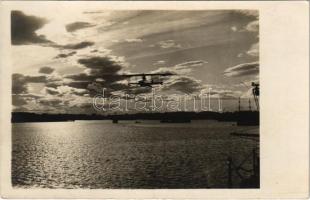 Ausflug bei Sonnenaufgang. K.u.K. Kriegsmarine Seeflugzeug / WWI Austro-Hungarian Navy, flying boat (hydroplane), most likely a Lohner, overflies the port. Verlag Rotes Kreuz Atelier, Pola 1916.