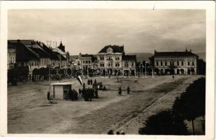 Kézdivásárhely, Targu Secuiesc; Fő tér bevonuláskor magyar zászlókkal, Winternitz Ödön, Mánya Ernő üzlete, mentőautó / main square during the entry of the Hungarian troops, shops, ambulance