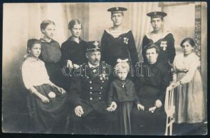 cca 1916 Egy haditengerész család. Az S.M.S. Warasdineren szolgáló egyik fiú, a másik tengeralattjárón szolgál, valamint az apa is tengerésztiszt Fotólap / Black-and-white privately made photo postcard A perfect depiction of a late Habsburg bourgeois family. The father, a naval official, poses with his wife, five daughters, and two sons. The taller of the two young men is a member of the crew of S.M.S. Warasdiner. The second young man, wearing two medals more than his brother, is clearly with the submarine service: the band on his cap reads Unterseeboot, followed by a mostly illegible Roman numeral.