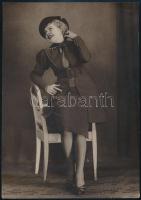 cca 1930 Vidám kisasszony széken, műtermi fotó, hátoldalán albumba ragasztás nyomaival, 20×16 cm