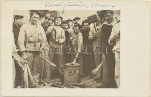 Az S.M.S. Babenberg osztrák-magyar hadihajó matrózai szárított halat vételeznek, fotólap. / A large group of sailors from S.M.S. Babenberg stand around several of their mates who, armed with huge mallets, are pounding some sort of dried fish (Stockfisch in German). The man in the center holding a mallet is identified as Rónai Larsson. Black-and-white photo postcard