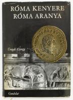 Ürögdi György: Róma kenyere, Róma aranya. Bp., 1969, Gondolat. Kiadói egészvászon-kötésben, szakadt, karcos kiadói papír védőborítóban.  &quot;A mű szerzője ... a régi Róma gazdasági életét ismerteti. Nem törekszik az ókori római gazdálkodás valamilyen politikai gazdaságtani jellegű elemzésére, hanem a művelt olvasó érdeklődését igyekszik felkelteni a rómaiak kevésbé ismert gazdasági élete iránt. Összefoglalja az ókori gazdasági tevékenység egyes területeiről - mezőgazdaságról, iparról, bányászatról, kereskedelemről, közlekedésről, pénzügyről stb. - szóló ismereteket, s azokat megelevenítő erővel tárja az olvasó elé. Hézagpótlónak tekinthetjük a műben kiadásra kerülő összeállításokat az ókori pénzekről és mértékekről. A kötetet több magyarázó rajz, sok, Magyarországon eddig még meg nem jelent fénykép teszi színessé és érzékletessé. Az előadott anyagot anekdoták, ókori történetek, irodalmi idézetek fűszerezik.&quot; (moly.hu)